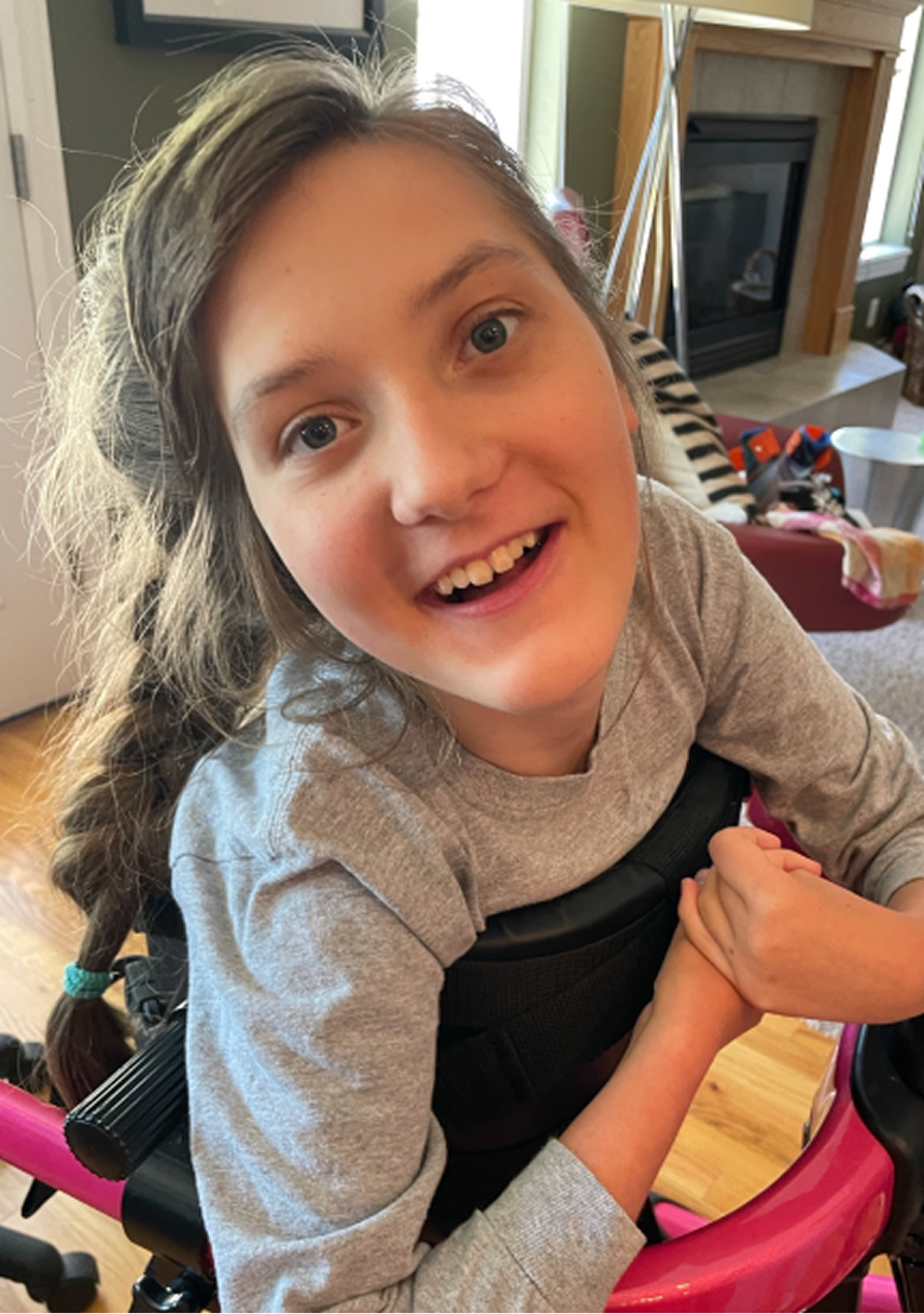 Lucy crosses her hands and smiles at the camera