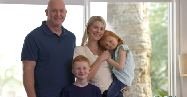 Minna’s family posing for the camera. Caroline is holding a smiling Minna next to Minna’s dad and brother, Oscar.